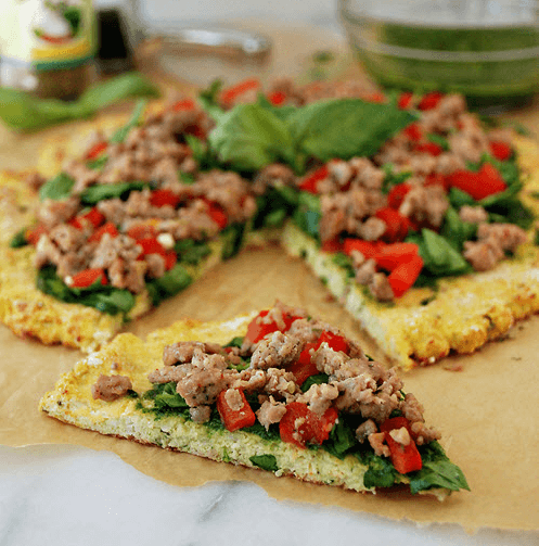 Cauliflower Pizza Crust with Sausage, Spinach, Tomatoes and Pesto